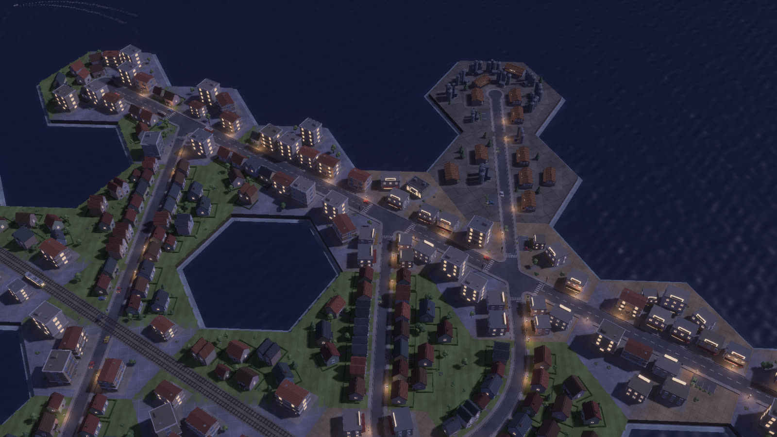 The hexagonal city at night with streetlights and lit windows
